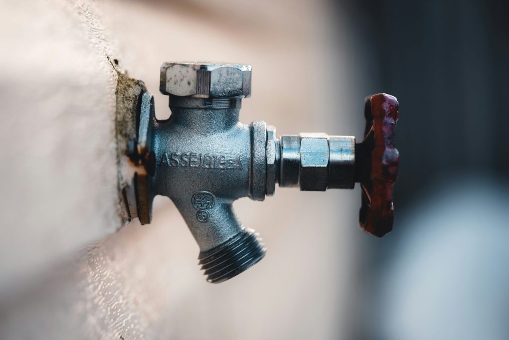 a close up of a water faucet attached to a wall